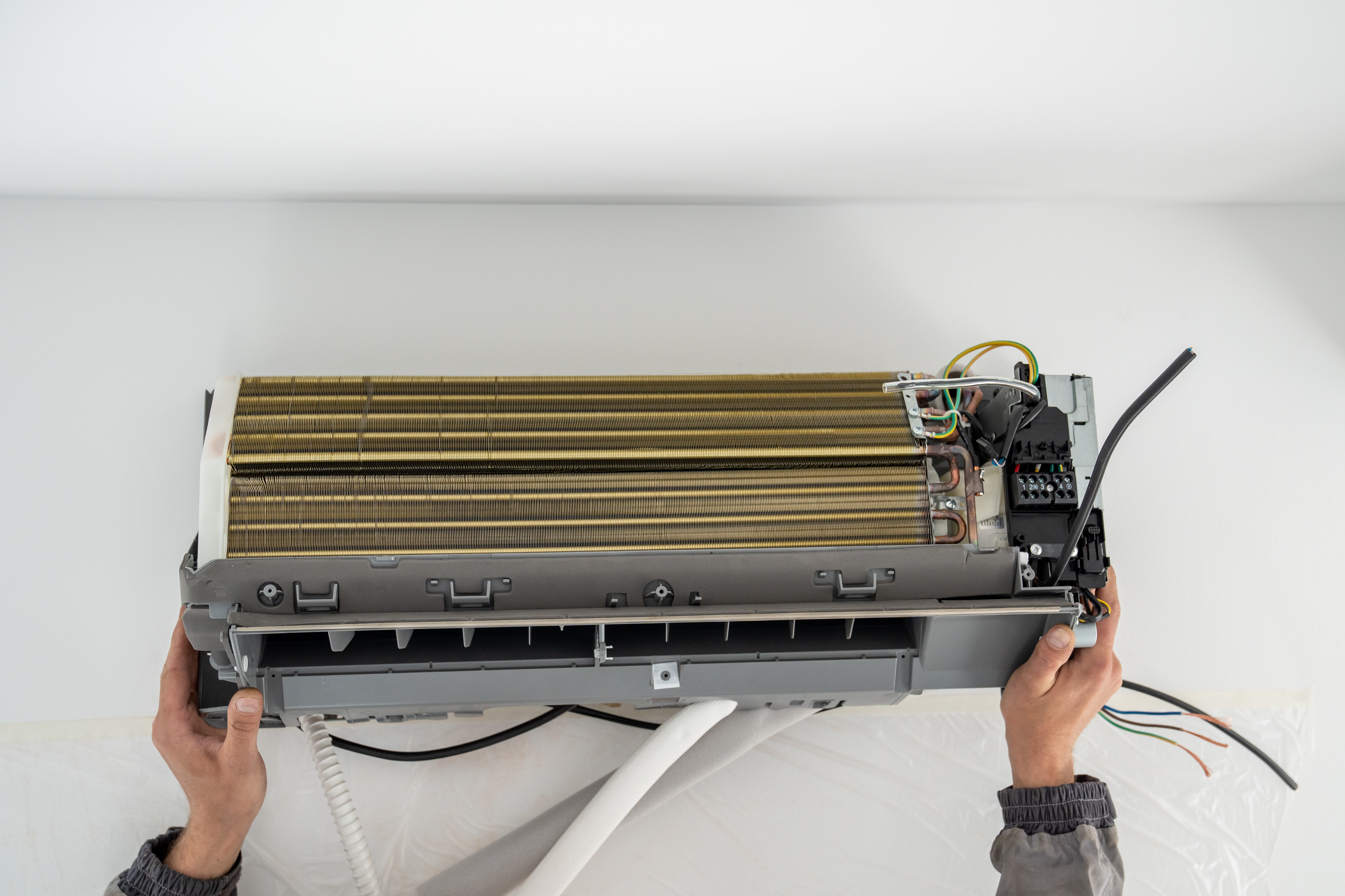 Installation air conditioning system in room with white wall in apartment, office closeup